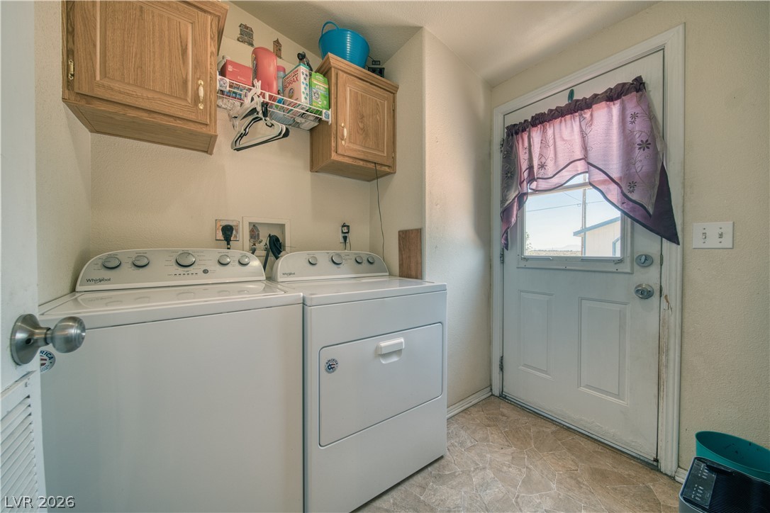 2931 Rio Rancho Drive, Unit 4 Pahrump, NV 89048 - Photo 16 of 21 Functional laundry space featuring modern appliances and upper storage cabinets for convenience.