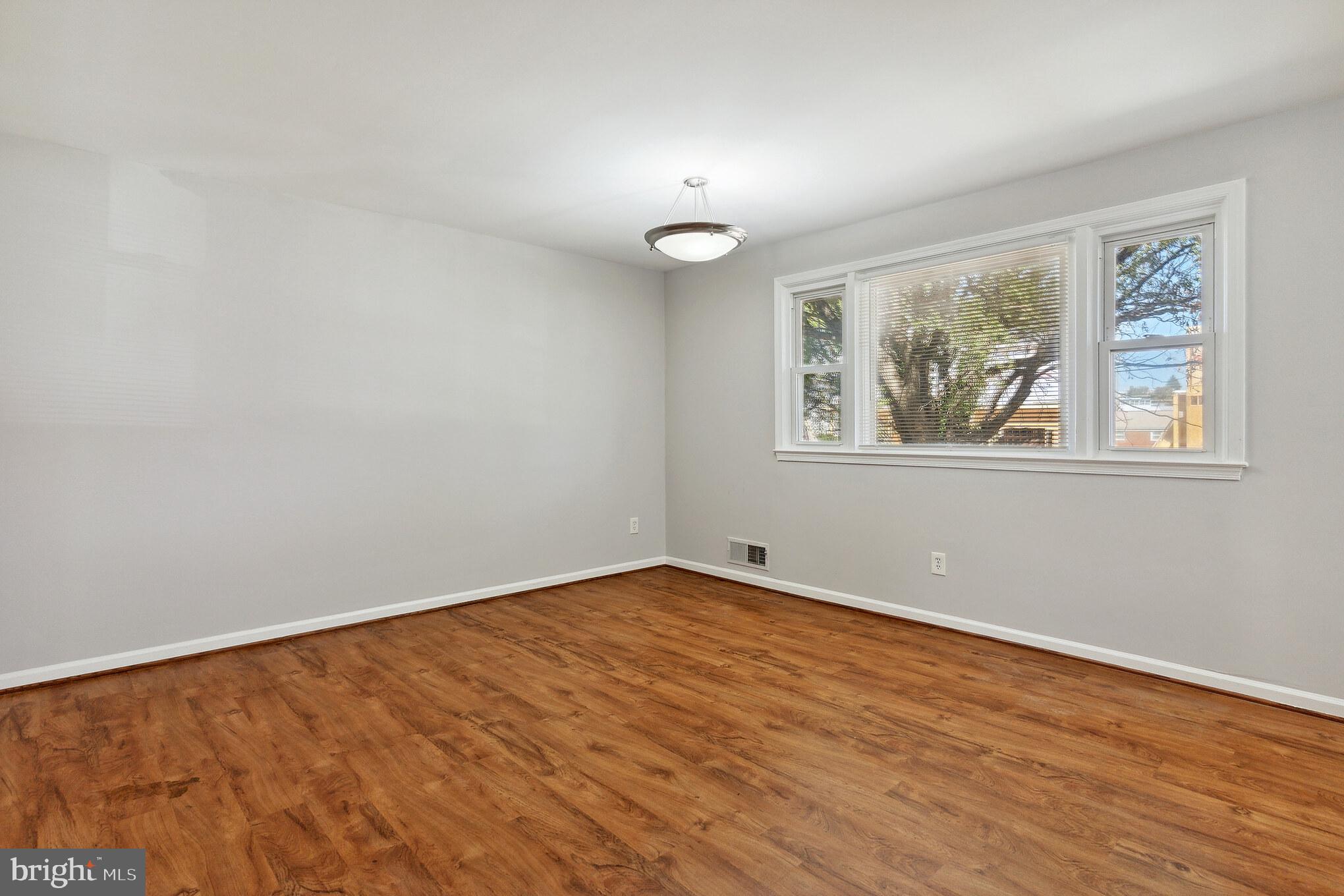 6414 Winnepeg Road Bethesda, MD 20817 - Photo 4 of 20 a view of an empty room with wooden floor and a window