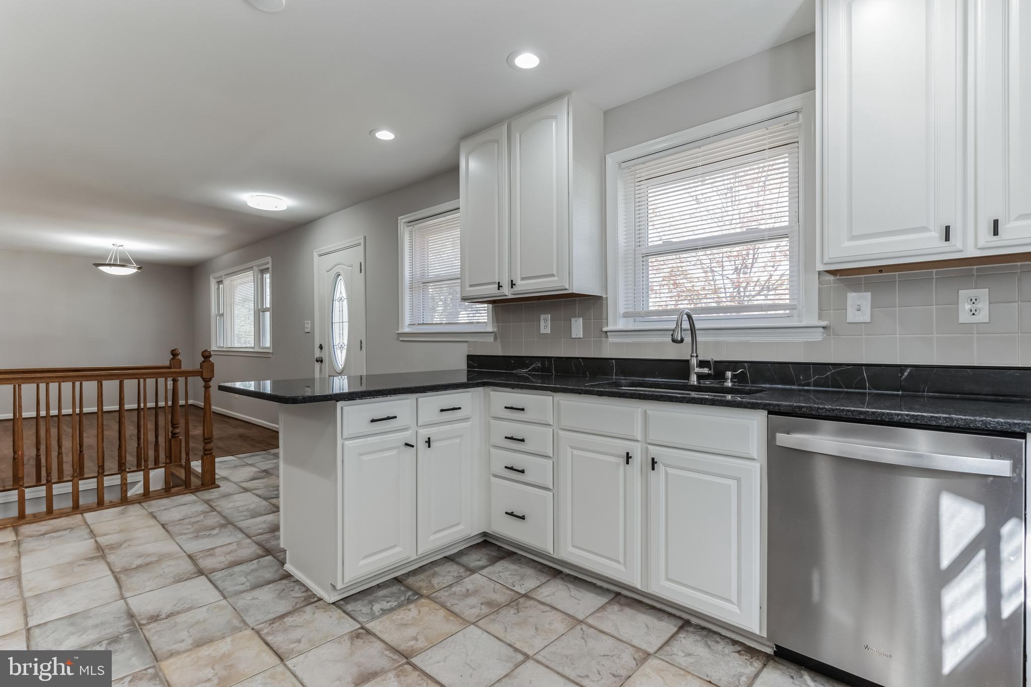 6414 Winnepeg Road Bethesda, MD 20817 - Photo 6 of 20 a kitchen with white cabinets granite counter tops and a window