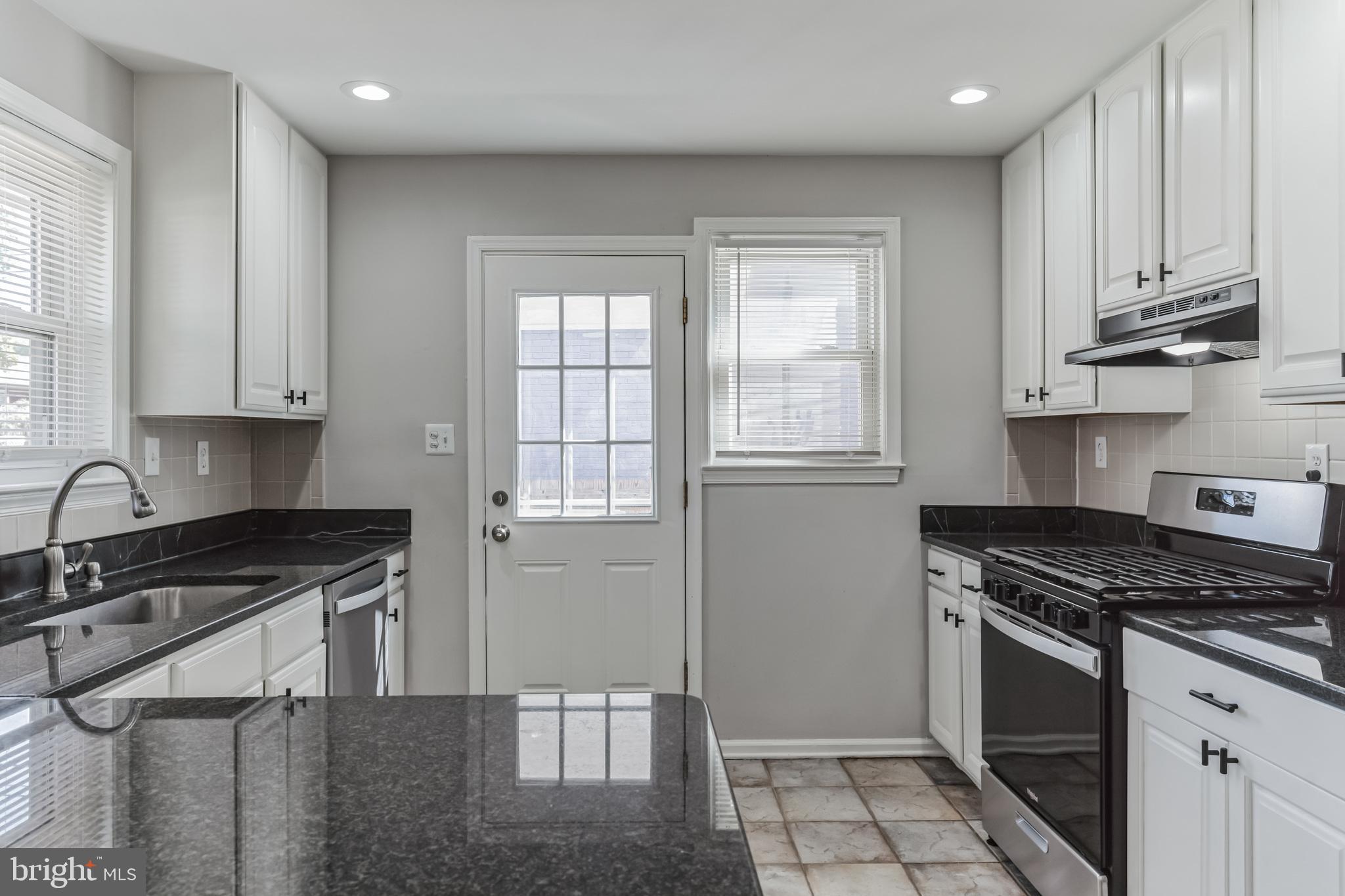 6414 Winnepeg Road Bethesda, MD 20817 - Photo 8 of 20 a kitchen with stainless steel appliances granite countertop a sink stove and cabinets