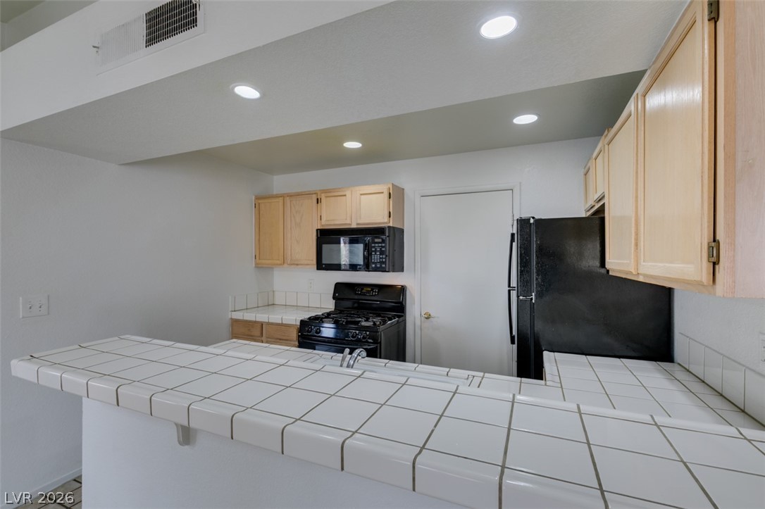 7570 West Flamingo Road, Unit 252 Las Vegas, NV 89147 - Photo 20 of 44 A streamlined kitchen presents ample counter space with integrated sink and modern appliances for efficient meal preparation.