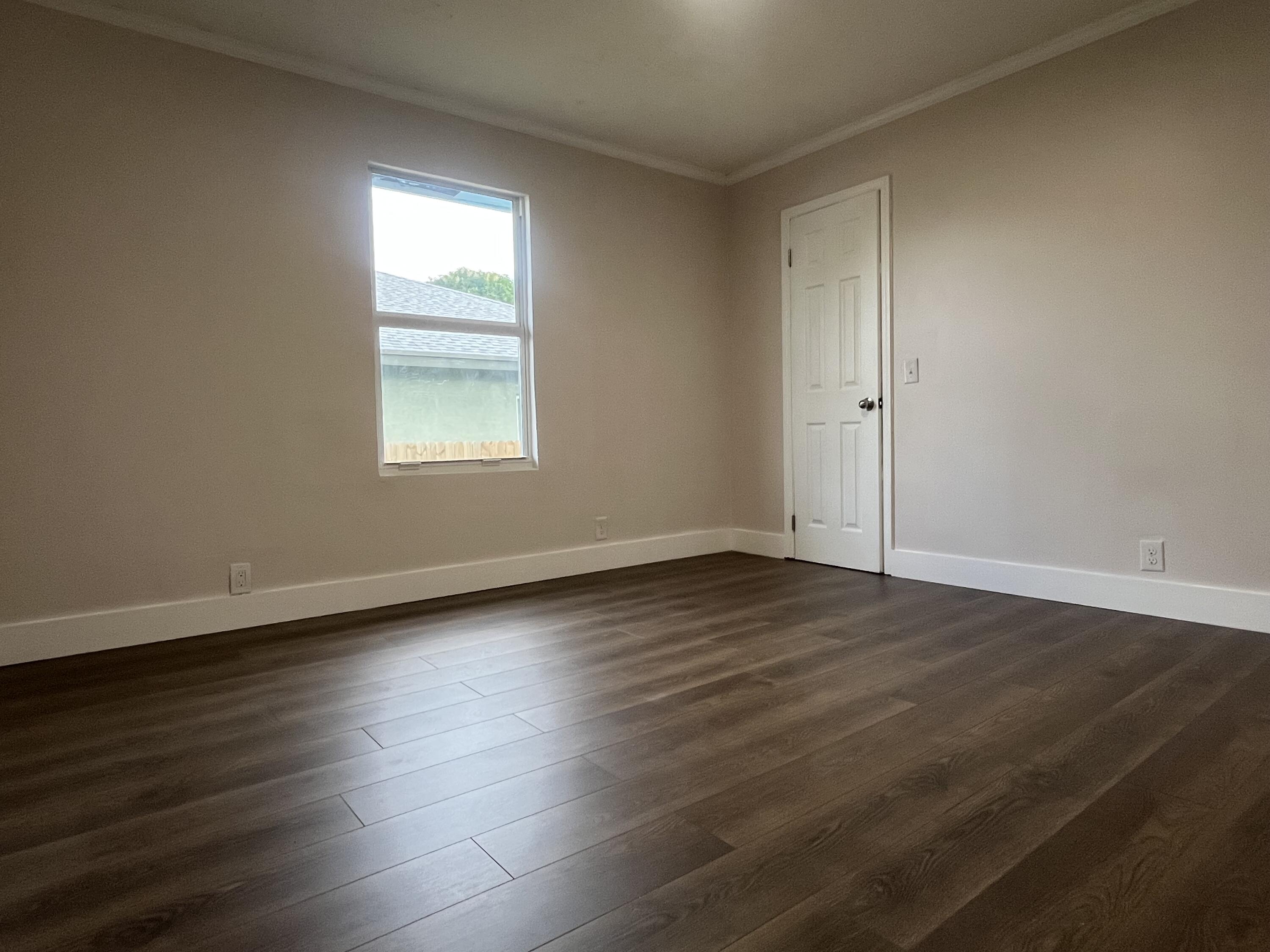 1457 West 32nd Street Riviera Beach, FL 33404 - Photo 2 of 5 an empty room with wooden floor and windows