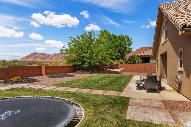 225 Falcon Court Ivins, UT 84738 - Photo 26 of 47 Fenced backyard with a mountain view, a patio, and a trampoline