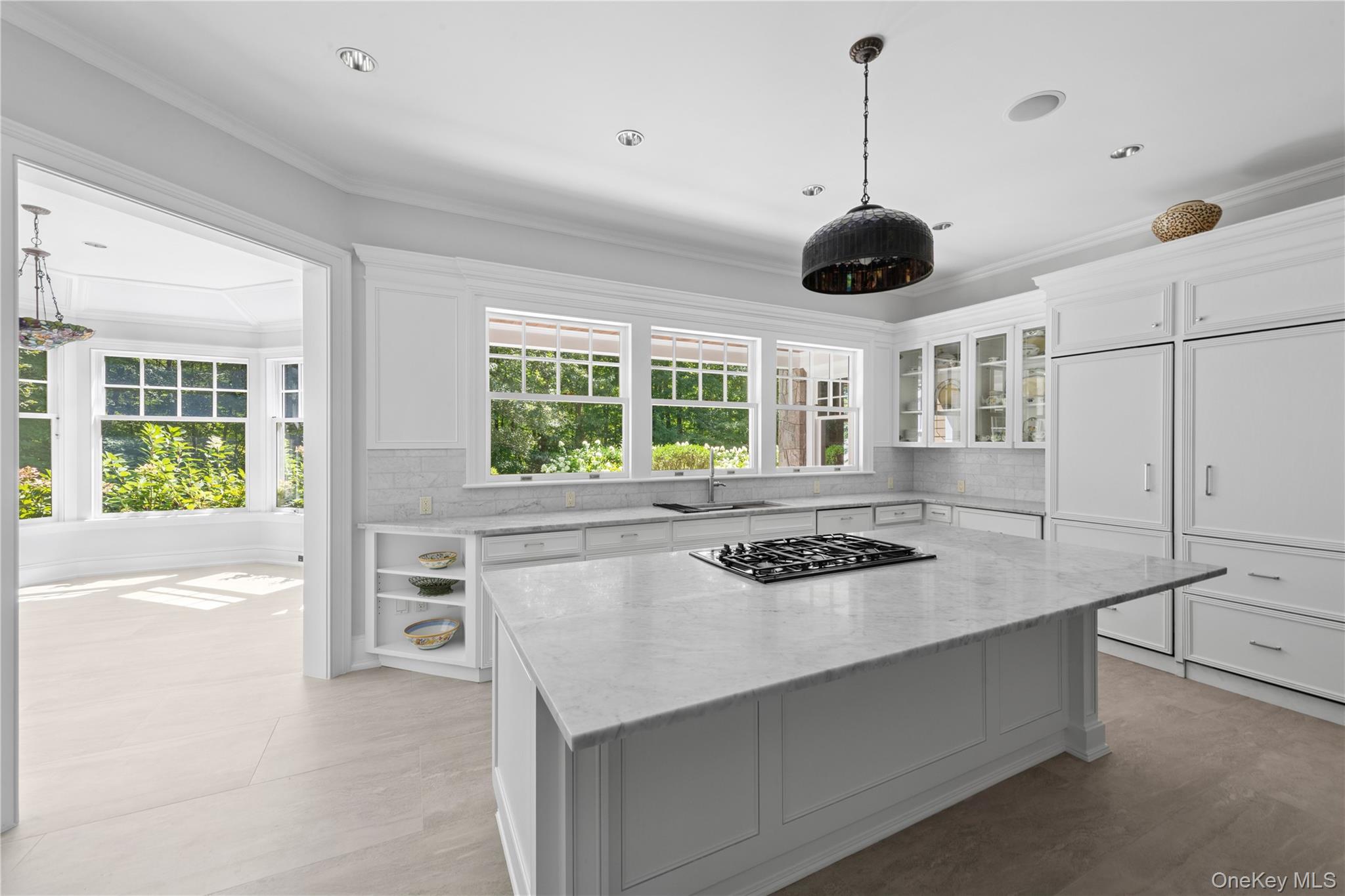284 West Patent Road Bedford, NY 10549 - Photo 7 of 40 Kitchen featuring decorative backsplash, light stone counters, white cabinets, crown molding, and plenty of natural light