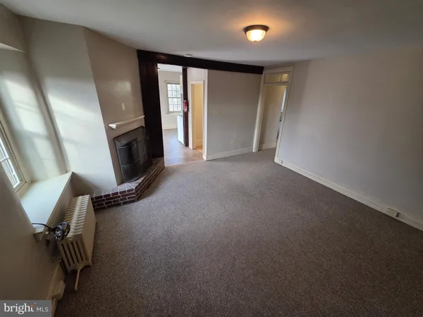 an empty room with fireplace and windows