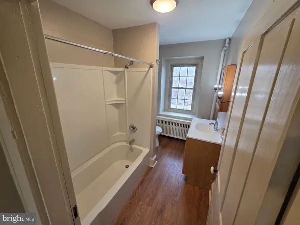 a bathroom with a tub shower vanity and a sink