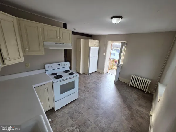 a kitchen with a stove and white cabinets