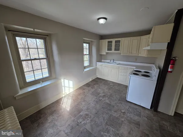 a view of a kitchen with fridge and wooden floor