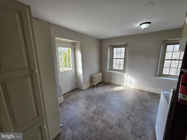 an empty room with windows and fireplace