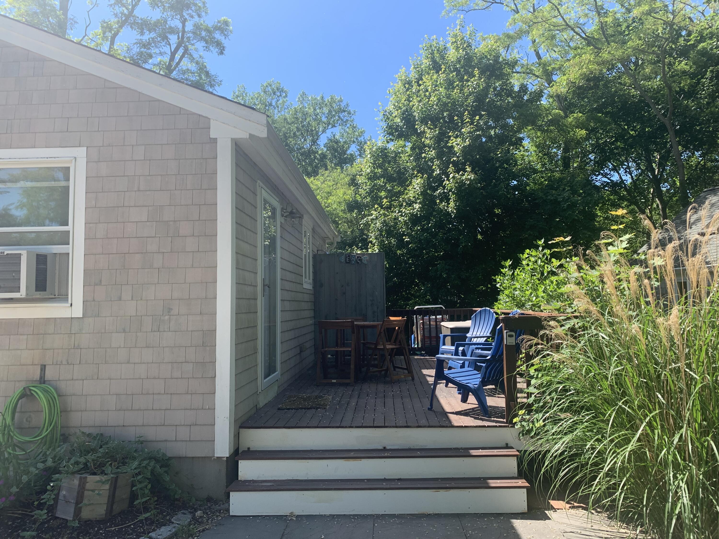 27 Locust Road, Unit 2 Eastham, MA 02642 - Photo 2 of 21 a view of a patio with table and chairs potted plants and floor to ceiling window and potted plants