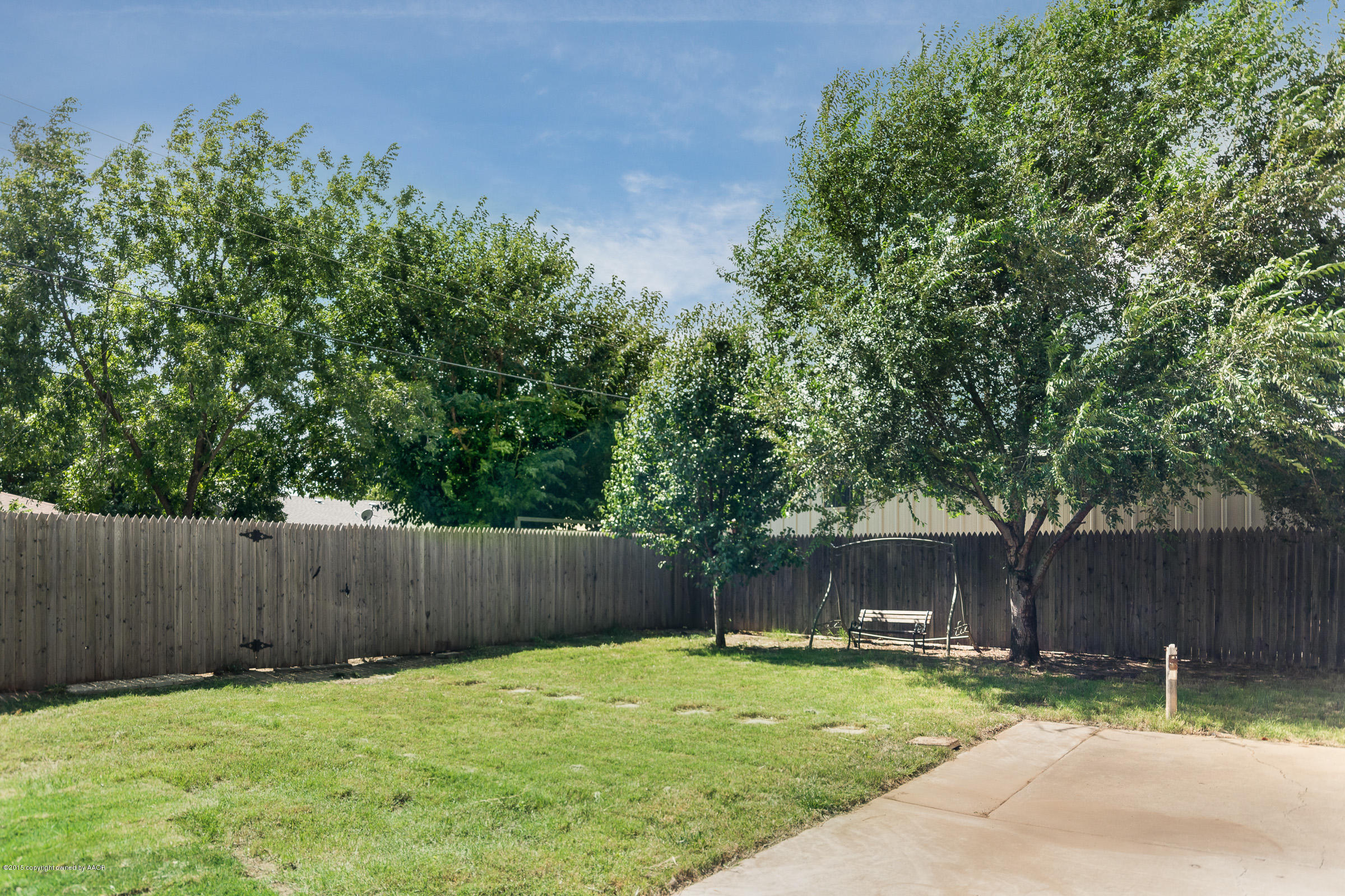 5017 Tulip Avenue Amarillo, TX 79110 - Photo 16 of 16 a backyard with wooden fence and a bench