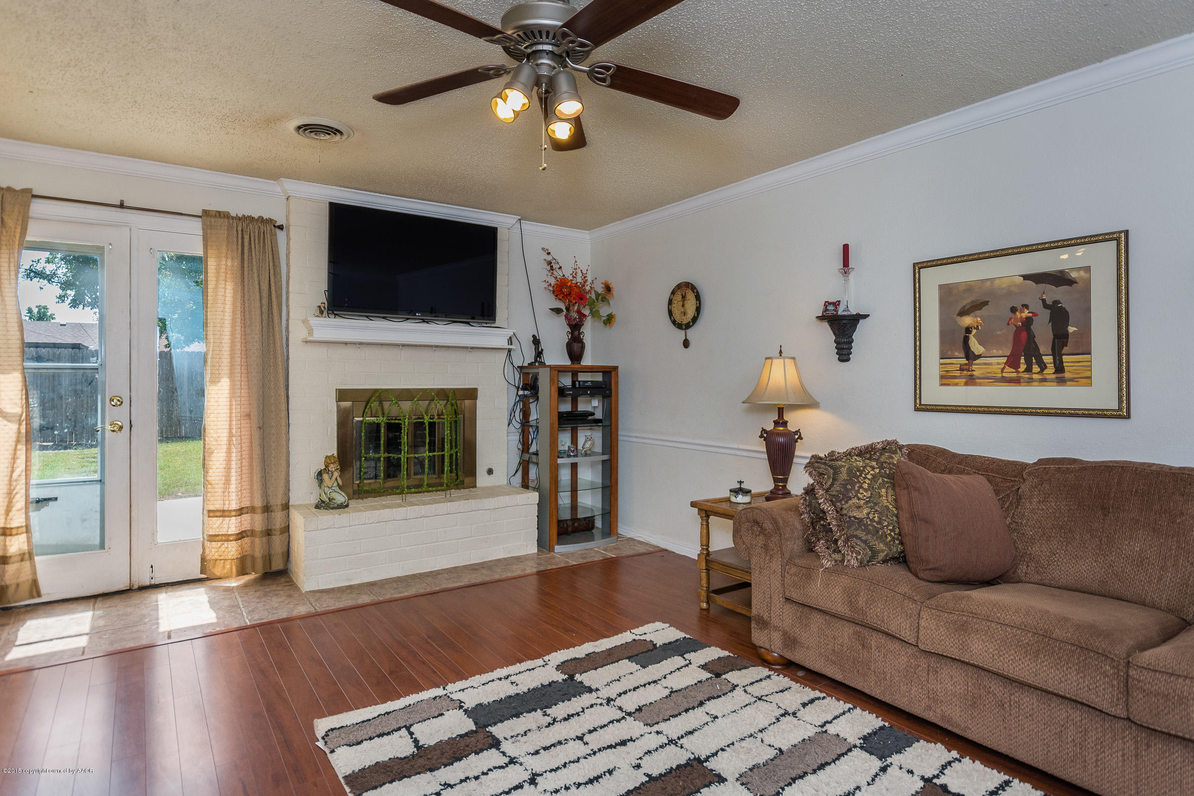 5017 Tulip Avenue Amarillo, TX 79110 - Photo 6 of 16 a living room with furniture a flat screen tv and a fireplace