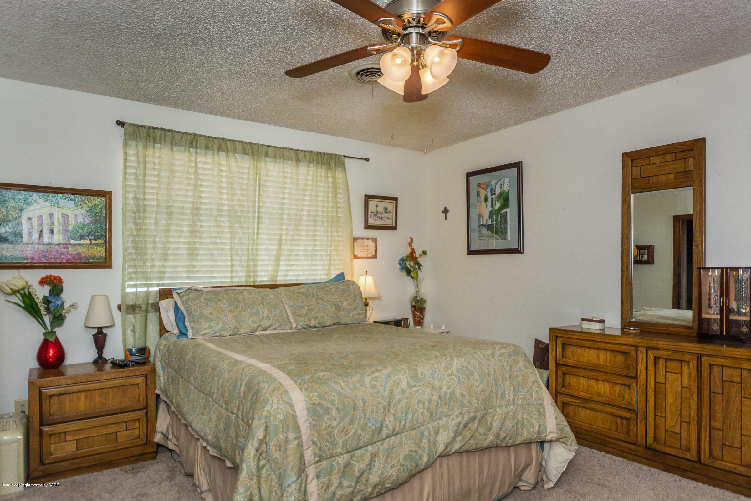 5017 Tulip Avenue Amarillo, TX 79110 - Photo 7 of 16 a bedroom with a bed and a chandelier