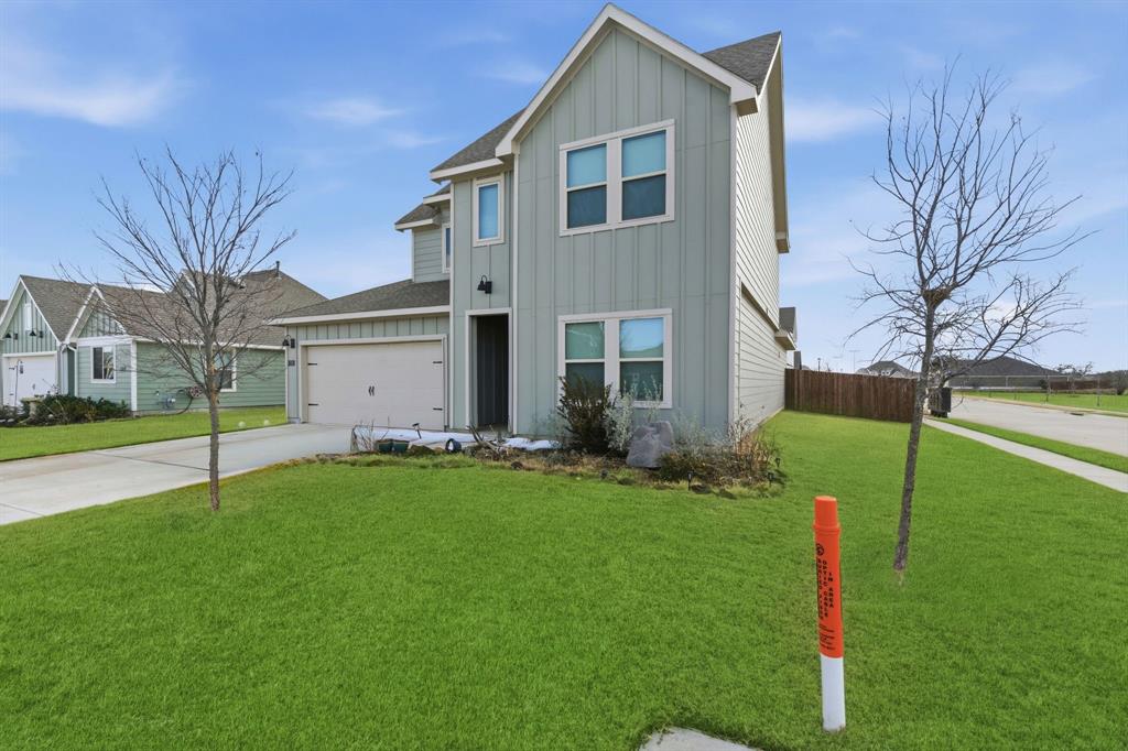 709 Primrose Lane Pilot Point, TX 76258 - Photo 2 of 35 View of front of property featuring board and batten siding, driveway, a shingled roof, and a garage