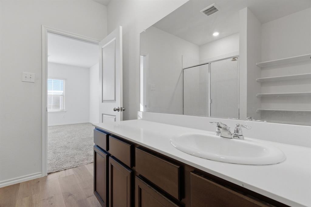 709 Primrose Lane Pilot Point, TX 76258 - Photo 23 of 35 Bathroom featuring a stall shower, light wood finished floors, and vanity
