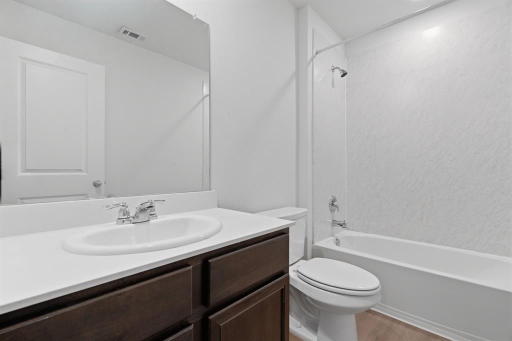 709 Primrose Lane Pilot Point, TX 76258 - Photo 24 of 35 Bathroom featuring shower combination, vanity, and light wood-style flooring