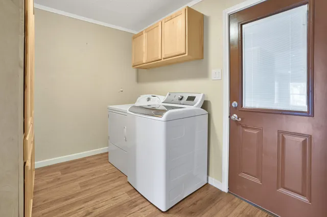 a utility room with wooden floor washer and dryer