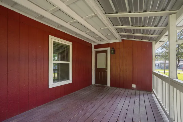 a view of a hallway with wooden floor and windows