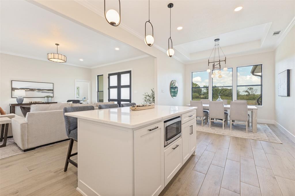 3150 Crisp Road Ennis, TX 75119 - Photo 11 of 30 Kitchen island with quartz countertop, integrated microwave, and pendant lighting