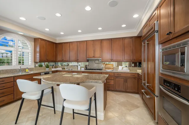 a kitchen with center island and large windows