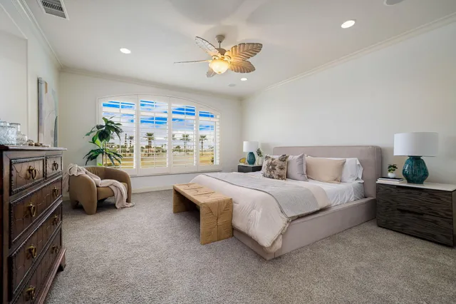 a bedroom with a bed chandelier and a window