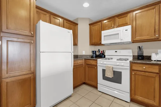 a white refrigerator freezer and a stove sitting inside of a kitchen