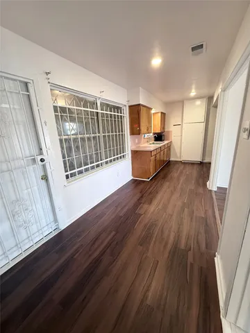 a view of a kitchen with wooden floor and electronic appliances