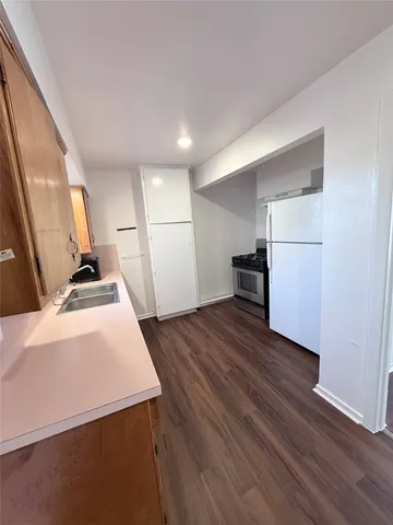 a kitchen with a refrigerator and a stove top oven