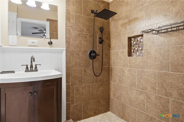 a bathroom with a shower sink and mirror