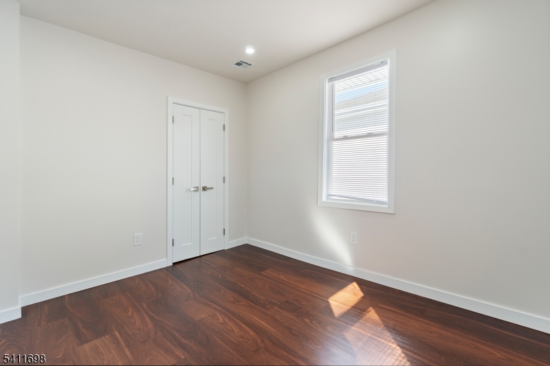 826 George Street, Unit 1 Plainfield, NJ 07062 - Photo 4 of 21 an empty room with wooden floor and windows