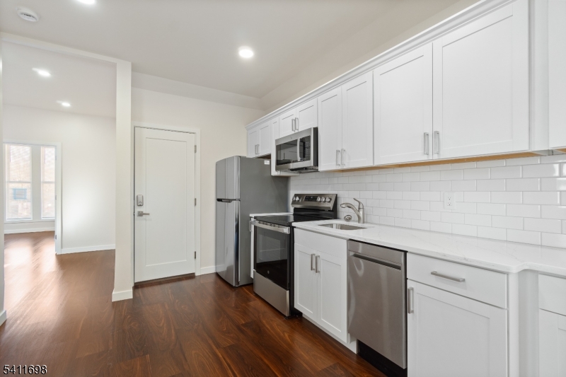 826 George Street, Unit 1 Plainfield, NJ 07062 - Photo 6 of 21 a kitchen with a sink cabinets stainless steel appliances and wooden floor