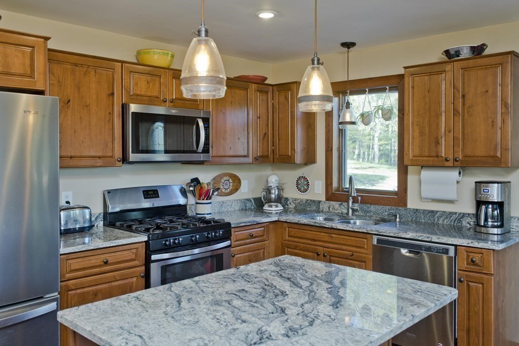 135 George Lamb Road Leyden, MA 01337 - Photo 12 of 42 a kitchen with kitchen island granite countertop wooden cabinets a stove a sink a refrigerator and a granite counter tops
