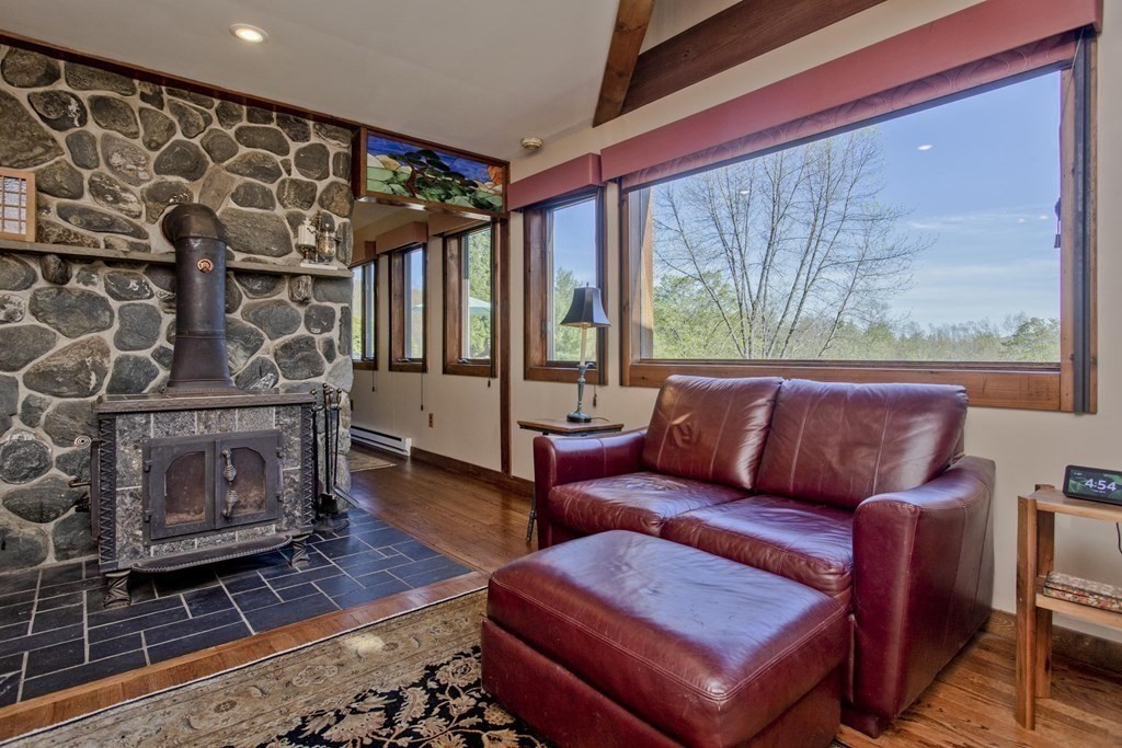 135 George Lamb Road Leyden, MA 01337 - Photo 16 of 42 a living room with furniture a flat screen tv and a fireplace