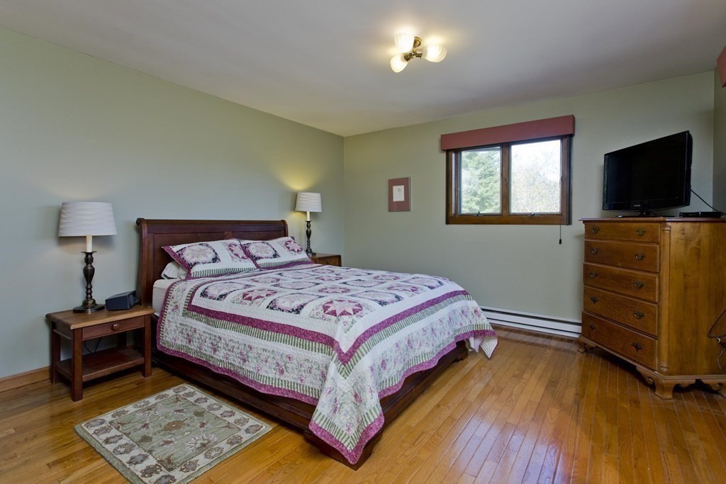 135 George Lamb Road Leyden, MA 01337 - Photo 34 of 42 a bedroom with a bed and flat screen tv