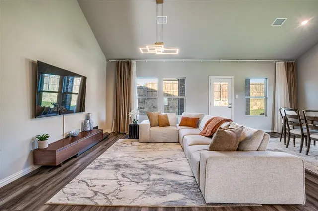a living room with furniture potted plant and a chandelier