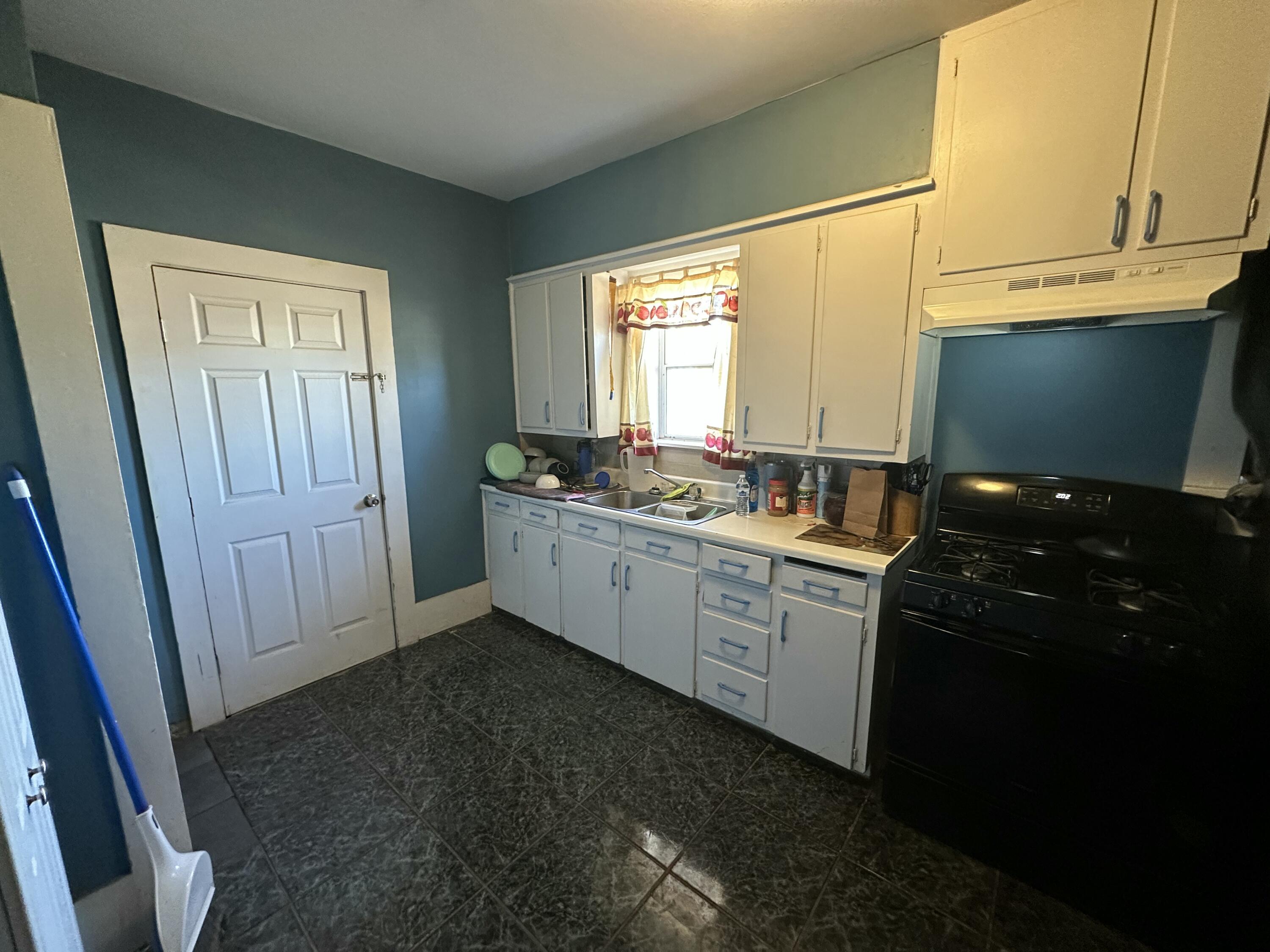 611 Denver Plainview, TX 79072 - Photo 4 of 8 a kitchen with a sink stove and cabinets