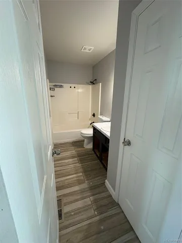 a kitchen with granite countertop a sink cabinets and wooden floor