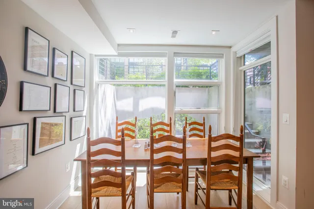 a view of a dining room with furniture a chandelier and windows