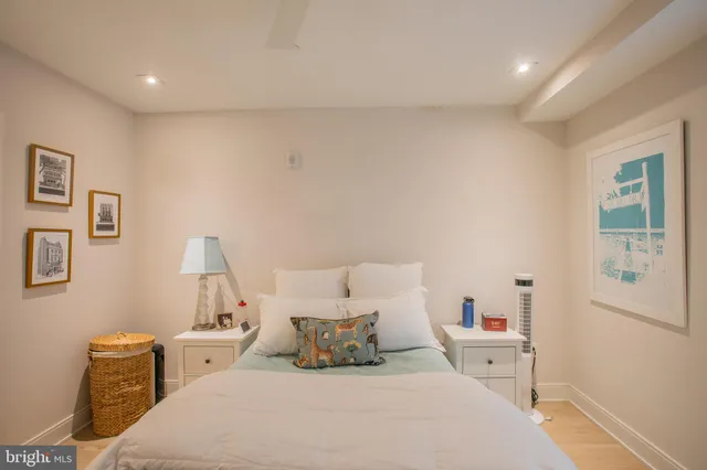 a large bedroom with bed and wooden floor