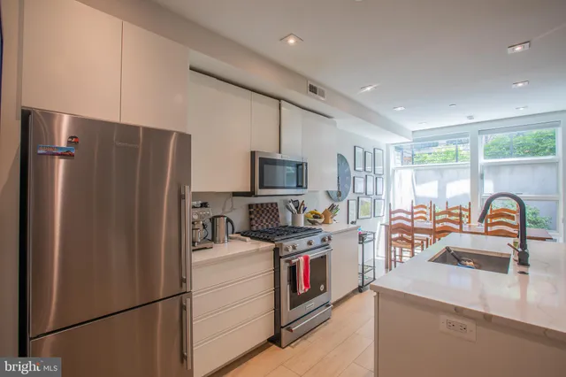 a kitchen with stainless steel appliances granite countertop a refrigerator stove and sink