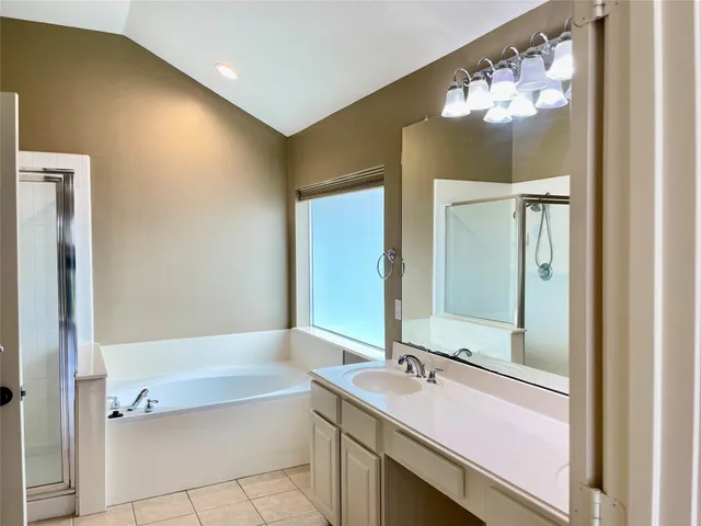 a bathroom with a tub sink and mirror