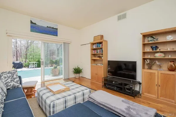 a living room with furniture a flat screen tv and a floor to ceiling window