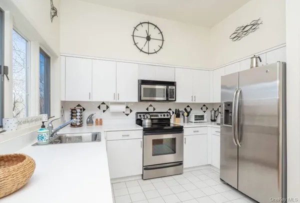 a kitchen with white cabinets and stainless steel appliances