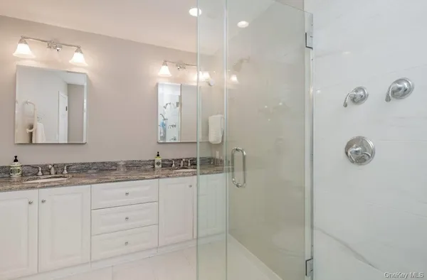 a bathroom with a granite countertop sink mirror and shower