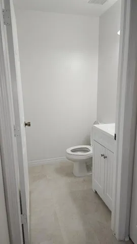 a white toilet sitting next to a white sink
