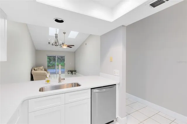 a kitchen with stainless steel appliances a sink and chandelier