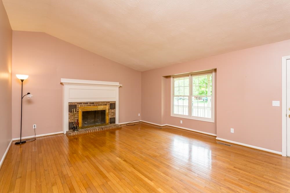 87 Bluestone Drive Weyers Cave, VA 24486 - Photo 8 of 37 an empty room with wooden floor fireplace and windows