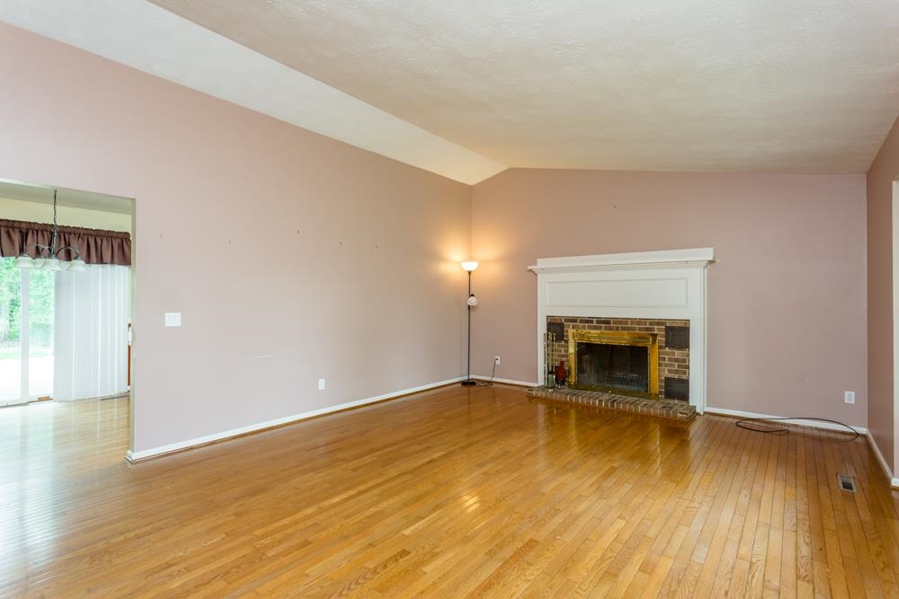 87 Bluestone Drive Weyers Cave, VA 24486 - Photo 9 of 37 a view of an empty room with wooden floor fireplace and a window