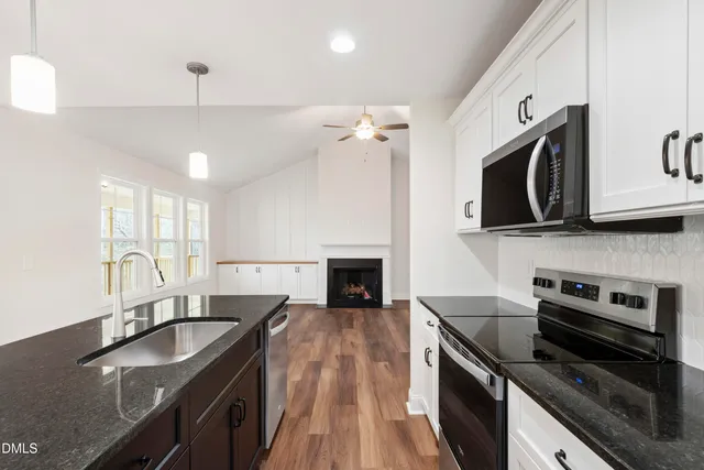 a kitchen with stainless steel appliances granite countertop a sink stove and microwave