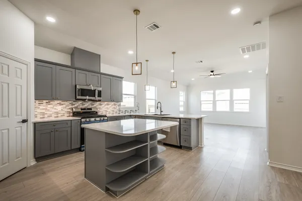 a kitchen with kitchen island granite countertop a sink stainless steel appliances and white cabinets